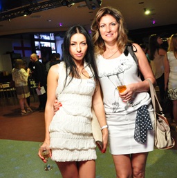 A photo of two beautiful foreign women at a social gathering, each holding a glass of champagne