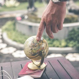 A photo of a man pointing to a globe