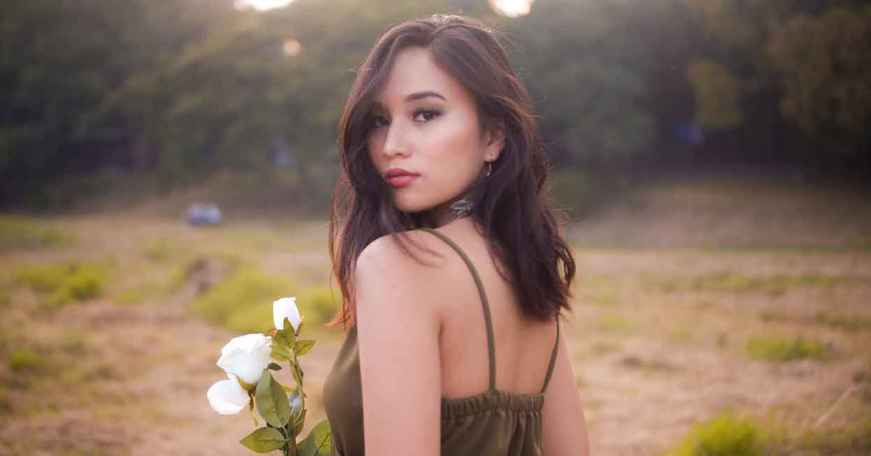 lady with white flowers looking at camera