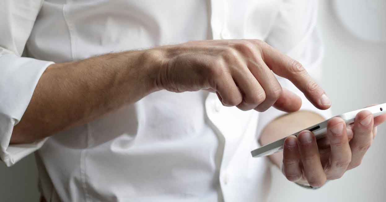 A photo of a man holding his phone