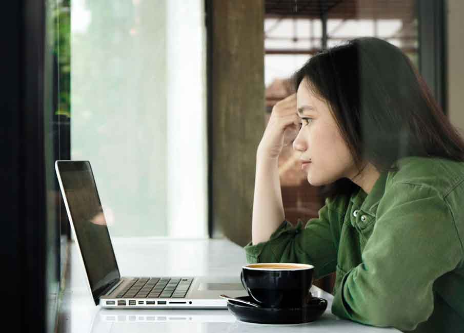 A girl in a green shirt uses her laptop