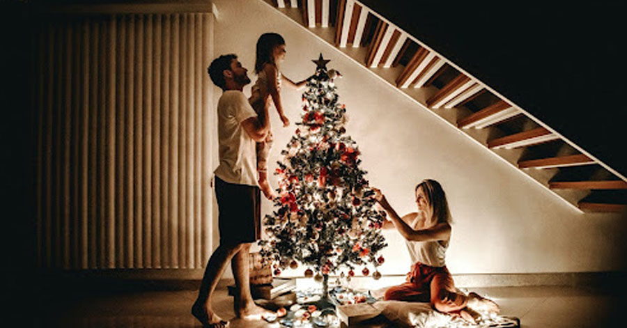 family decorating a christmas tree