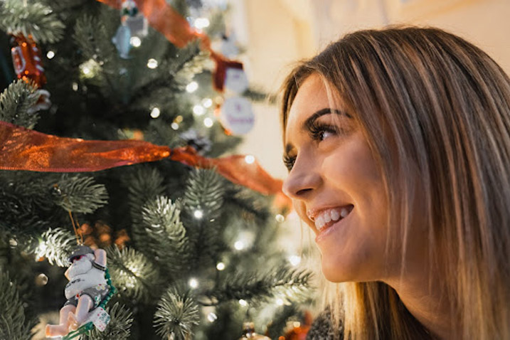 girl smiling with a christmas tree in the background